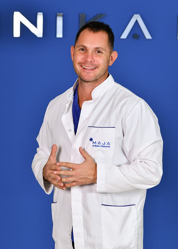 Doc. dr Marko Zlatanović u belom mantilu ispred plavog zida Klinike Maja u Nišu